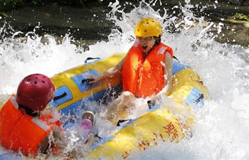 Tourists splash water to shield from heat in east China's Shandong