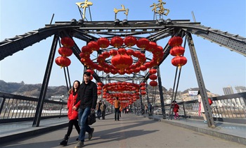 Red lanterns hung over century-old iron bridge to celebrate Spring Festival