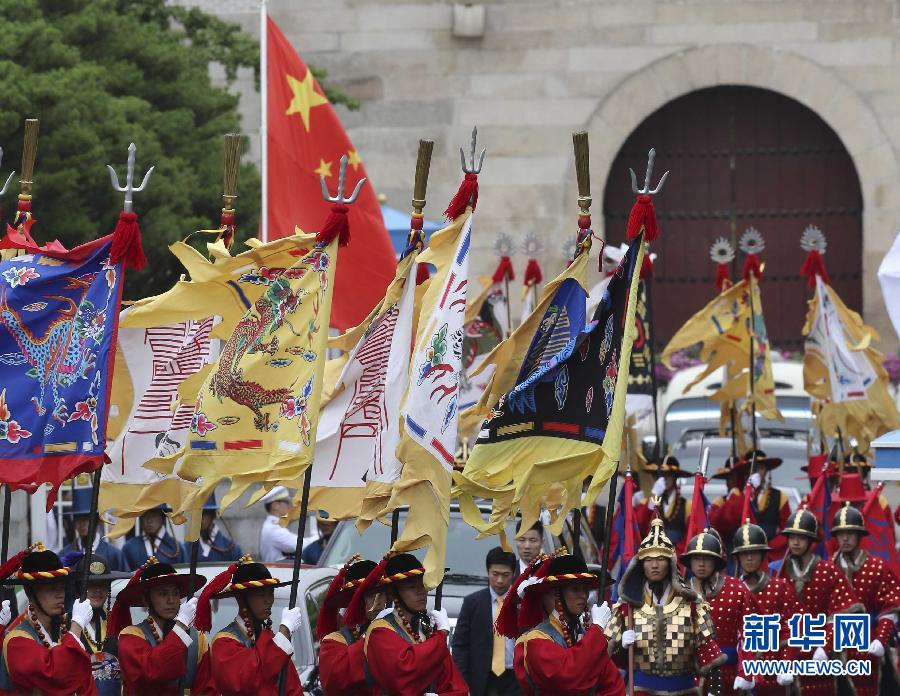 7月3日，韓國總統(tǒng)樸槿惠在青瓦臺(tái)總統(tǒng)府舉行隆重儀式，歡迎中國國家主席習(xí)近平對(duì)韓國進(jìn)行國事訪問。這是習(xí)近平的車隊(duì)在身著民族服裝的韓國禮儀隊(duì)伍引導(dǎo)下駛?cè)肭嗤吲_(tái)。新華社記者丁林?jǐn)z  